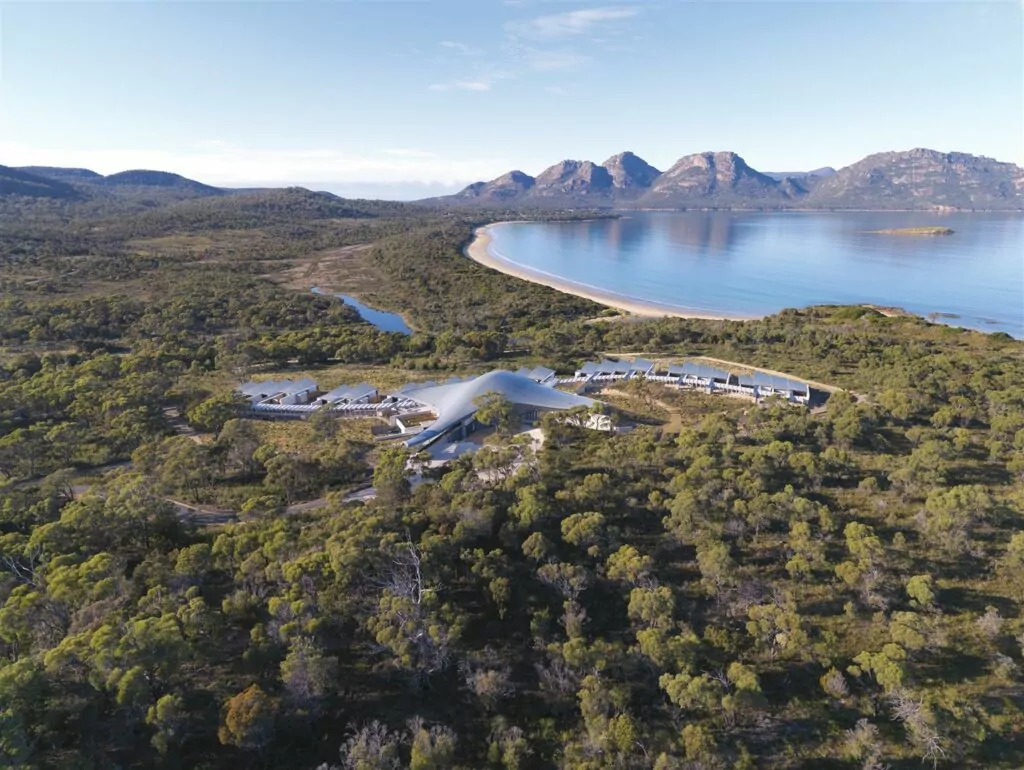 Aerial drone photo of the Saffire Freycinet luxury resort, surrounded by the picturesque Coles Bay, forest and mountain surroundings.