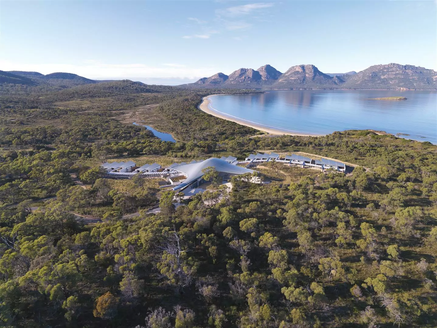 Aerial drone photo of the Saffire Freycinet luxury resort, surrounded by the picturesque Coles Bay, forest and mountain surroundings.