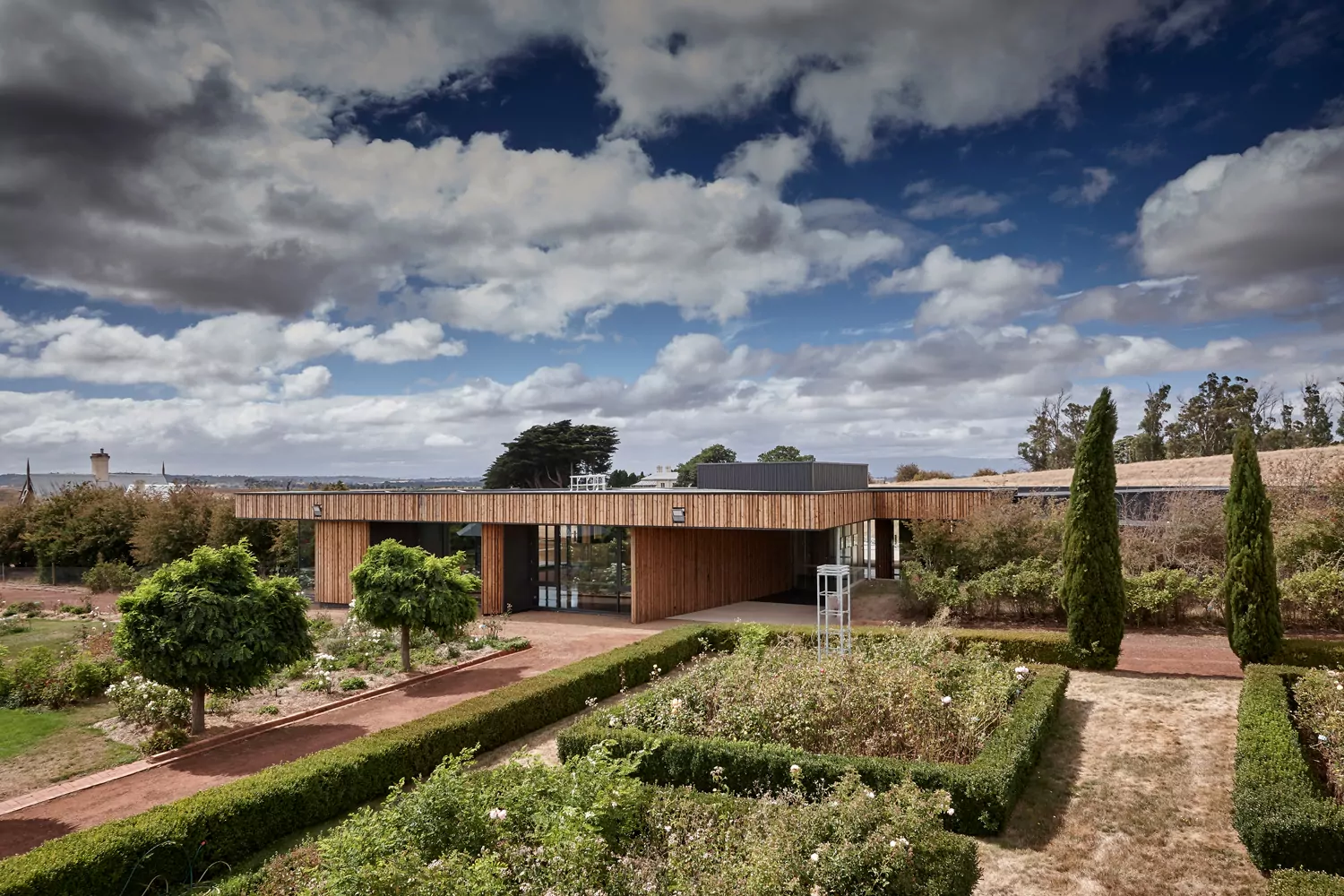 The exceptionally well-manicured rose garden of the world-heritage listed Woolmers Estate. Behind garden is the visitor centre and art gallery with its Finnish timber.