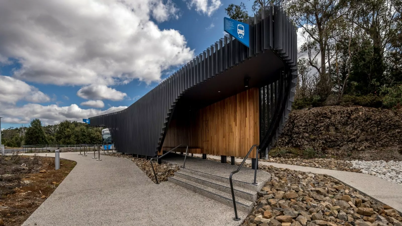 Small steps lead up to a sheltered waiting area to catch the bus at the Cradle Mountain Gateway.