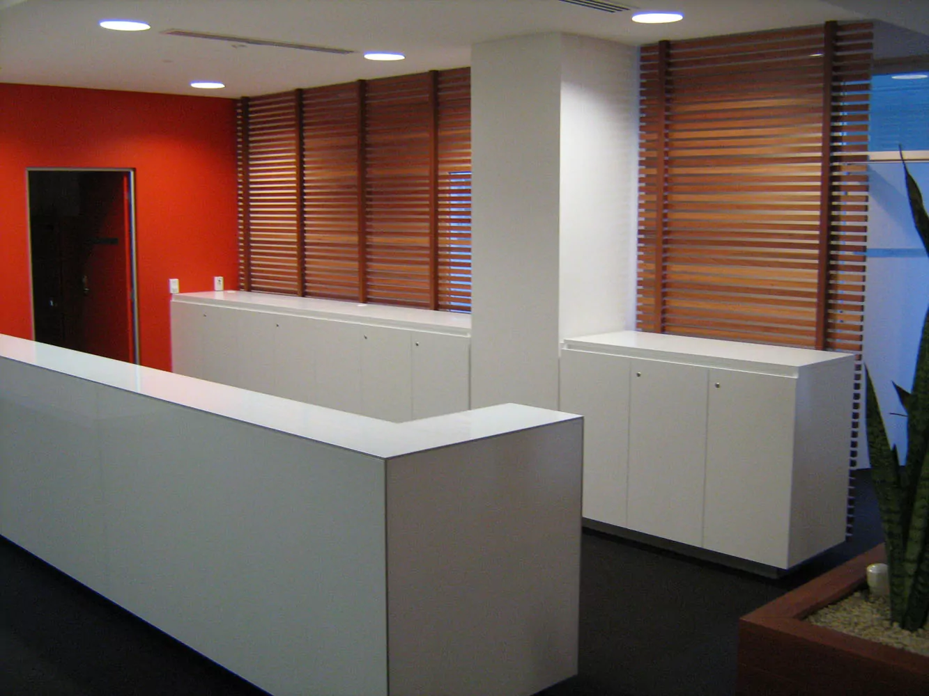 Two rows white cabinets in the BMRI Sydney office lead to a red-painted wall.