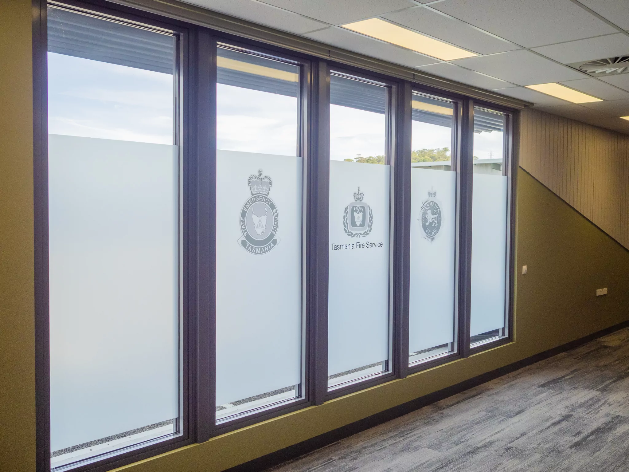 A photo of glass frosting depicting the logos of the Tasmanian Emergency State Services, Tasmanian Fire Service and Tasmanian Police.